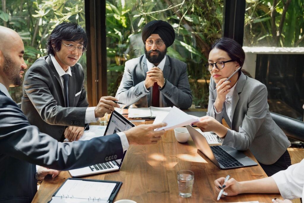 Executive team reviewing compliance documentation together around a conference table.